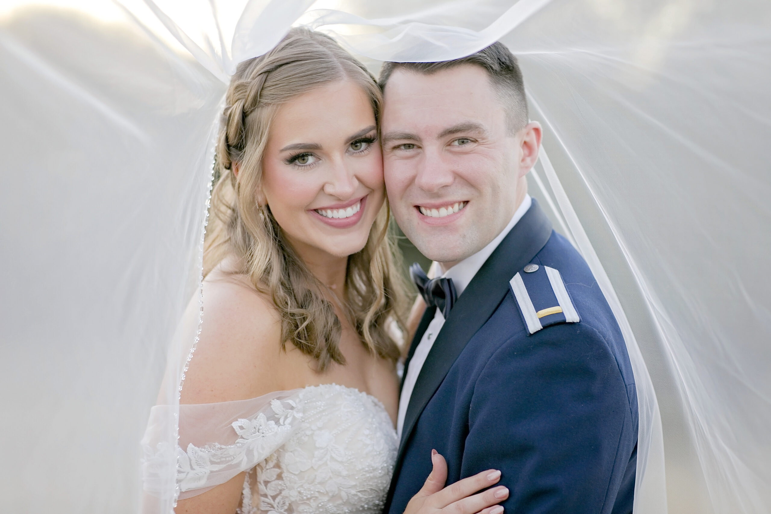 “Rachel and Nick sharing a joyful moment at their December wedding at Hidden River Ranch in Lampasas, Texas, surrounded by festive Christmas decor and glowing golden hour light.”