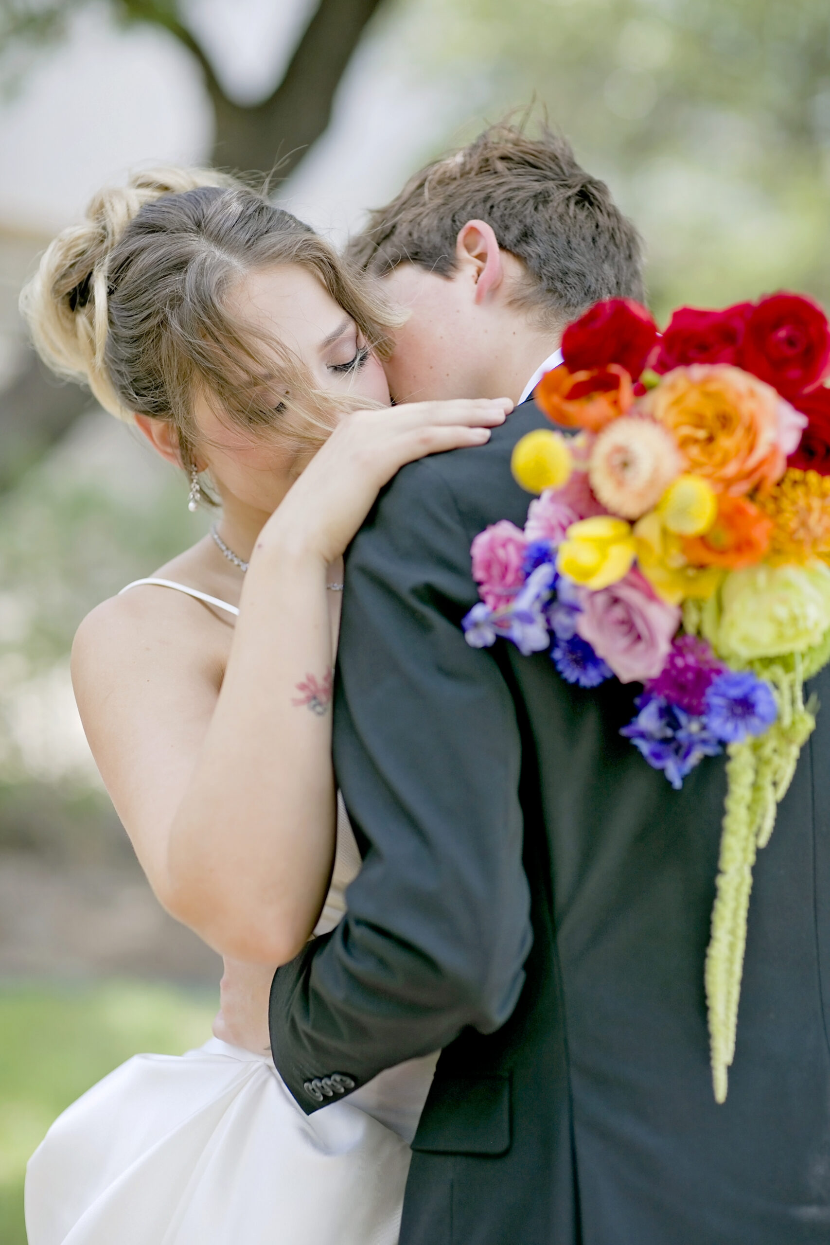 Couple embracing and smiling during a colorful Pride Month styled wedding photoshoot in Texas, celebrating love, inclusivity, and authentic connection.