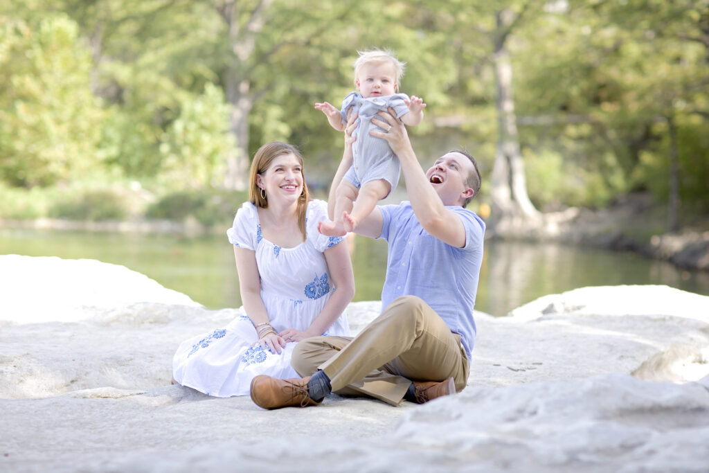 San Antonio family portraits of parents playing with their baby at McKinney Falls