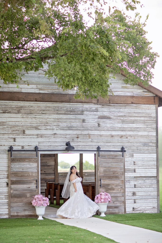 Bride holding her wedding dress outside The Fields Venue in Cibolo